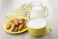 Shortbread in yellow saucer, jug and cup with milk Royalty Free Stock Photo