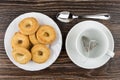 Shortbreads in plate, teabag in cup and spoon on table Royalty Free Stock Photo