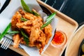 Shot from above Several pieces of battered chicken wings are fried until crispy and garnished on a white plate for a beautiful