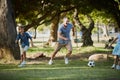 Giving dad a run for his money. Shot of an adorable little boy playing soccer with his father in the park. Royalty Free Stock Photo