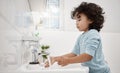 Kids need to keep their hands clean. Shot of an adorable little boy washing his hands at a tap in a bathroom at home. Royalty Free Stock Photo