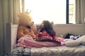 Would you like me to show you the pictures again. Shot of an adorable little girl reading a book with her teddy bear in Royalty Free Stock Photo