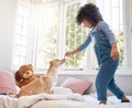 cherished friendship with every heartbeat. Shot of an adorable young boy playing with his dog in his bedroom at home. Royalty Free Stock Photo