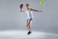 Adult fitness woman playing padel indoor. Isolated on white.