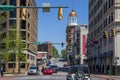 A shot along Georgia Avenue with cars driving along the street surrounded by office buildings and people walking on the street