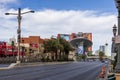 A shot along the Las Vegas strip with hotels and restaurants, cars driving on the street, lush green palm trees