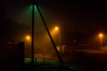 A foggy derelict street near the city centre is lit up by streetlights