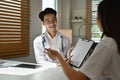 Shot of asian male doctor explaining medicine dosage to patient. Medicine, healthcare and people concept Royalty Free Stock Photo