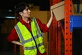 Shot of asian male worker suffering from back injury while lifting boxes in warehouse Royalty Free Stock Photo