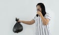 Shot of Asian woman holding a smelly a black garbage bag isolated on white background Royalty Free Stock Photo