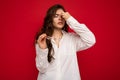 Shot of attractive sorrowful sad upset young curly brunette woman wearing white shirt and optical glasses isolated on