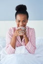 Her smile makes a every morning a little brighter. Shot of an attractive young woman enjoying her morning coffee in bed Royalty Free Stock Photo