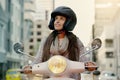 Its a big world out there, explore it. Shot of an attractive young woman riding her scooter through the city. Royalty Free Stock Photo