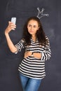 A shot of attractive young woman standing in front of blackboard