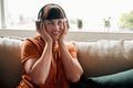 Music takes me to my happy place. Shot of an attractive young woman wearing headphones while relaxing on the sofa at Royalty Free Stock Photo