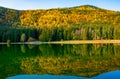 Shot of autumn scenery of Lake Saint Ann in Romania, lush colorful trees reflected in the water Royalty Free Stock Photo