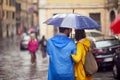 Shot from back of a young couple in love who is walking the city on a rainy day. Walk, rain, city, relationship Royalty Free Stock Photo