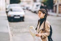 A shot of a beautiful caucasian woman traveling and reading a map to determine her next destination.