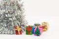 Shot of beautiful colorful gift boxes under the lush silver Christmas tree, festive mood Royalty Free Stock Photo