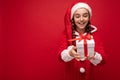 Shot of beautiful happy smiling brunette girl isolated over red background wall wearing new year santa claus outfit Royalty Free Stock Photo