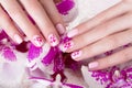 Shot beautiful manicure with flowers on female fingers. Nails design. Close-up Royalty Free Stock Photo