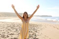 Shot of a beautiful smiling woman with raised arms on Lanzarote sand beach in summer dress Royalty Free Stock Photo