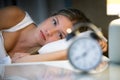 Beautiful young exhausted woman suffering insomnia lying on bed in bedroom at home. Royalty Free Stock Photo