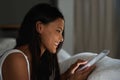 Staying in touch has never been easier. Shot of a beautiful young woman relaxing in bed with her tablet. Royalty Free Stock Photo