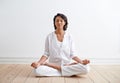 Mind, body and spirit aligned. Shot of a beautiful young woman sitting in the lotus position during a yoga session. Royalty Free Stock Photo