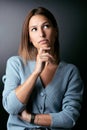 Beautiful young woman thinking on her worries over black background