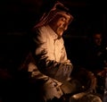 Shot of a Bedouin preparing dinner in a traditional style at night near the fire