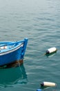 Shot of a blue classic fishing boat hanging in the dark turquoise water at the harbor