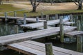 A shot of a brown wooden foot bridge over a still green lake in a Japanese garden surrounded by yellow winter grass Royalty Free Stock Photo