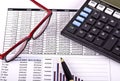 Financial tools, calculator, pen and specs over a report Royalty Free Stock Photo