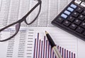 Financial tools, calculator, pen and specs over a report Royalty Free Stock Photo