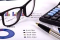 Financial tools, calculator, pen and specs over a report Royalty Free Stock Photo