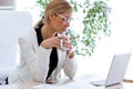 Business young woman drinking coffee while working with her laptop in the office. Royalty Free Stock Photo