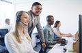 Game of phones. Shot of a businessman and businesswoman using a headset and computer while working in a modern office. Royalty Free Stock Photo