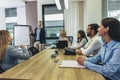 Businessman giving a presentation to her colleagues on a whiteboard in a boardroom Royalty Free Stock Photo