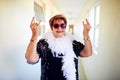 Ready to rock out. Shot of a carefree elderly woman wearing glasses and showing hand gestures to the camera. Royalty Free Stock Photo