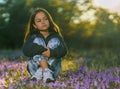 shot of a Caucasian little girl sitting in a field full of purple flowers