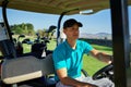 Going to the next hole. Shot of a cheerful young man driving in a golf cart to the next hole on a golf course. Royalty Free Stock Photo