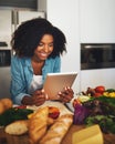 Looks like Im doing everything right. Shot of a cheerful young woman browsing on a digital tablet while being surrounded Royalty Free Stock Photo