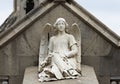 Angel with flowers sitting on the grave Royalty Free Stock Photo