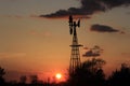 Kansas colorful Sunset with clouds and a tree and Windmill  silhouette with the Sun out in the country. Royalty Free Stock Photo