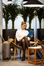 Concentrated young businesswoman working with her digital tablet sitting in the hotel lobby Royalty Free Stock Photo