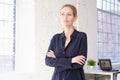 Attractive blond businesswoman sitting on the top of the office desk and looking thoughtfully Royalty Free Stock Photo