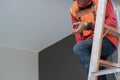 Shot of construction site builder climbing on ladder and preparing to fix rooftop Royalty Free Stock Photo