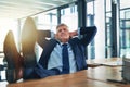 It feels good to be the boss. Shot of a contented businessman relaxing with his feet on his desk.