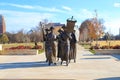 a shot of the copper statues at the Tennessee Woman`s Suffrage Monument with blue sky and clouds surrounded by autumn colored tree